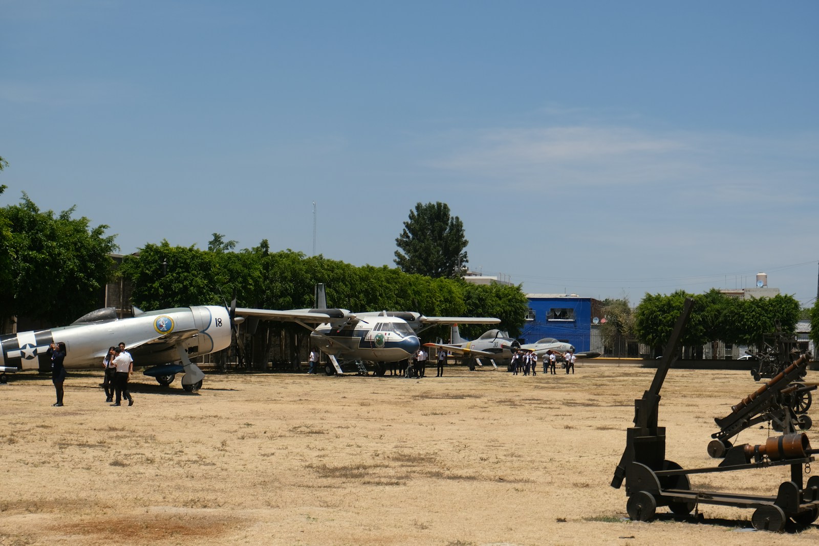 Airplanes displayed outdoors under a bright sky.