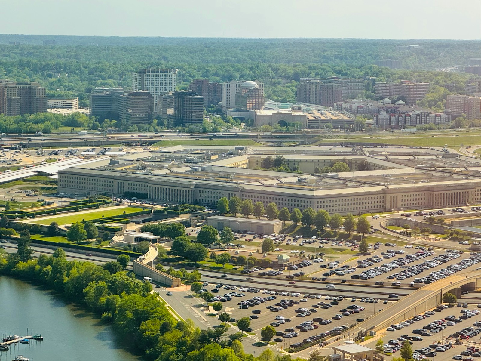 The pentagon building with surrounding parking lot and trees.